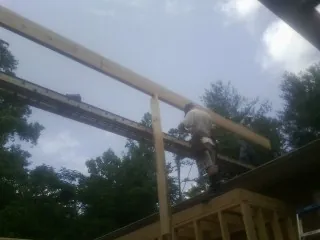 Carpenter setting a ridge beam over a new addition frame — Ice Dam Removal by Roofing Brothers in Stantonsburg