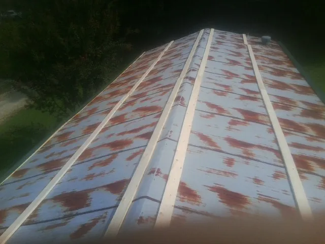 Rusted metal roof panels with new wood purlins before replacement — Storm Damage Roof Repair in Stantonsburg by Roofing Brothers