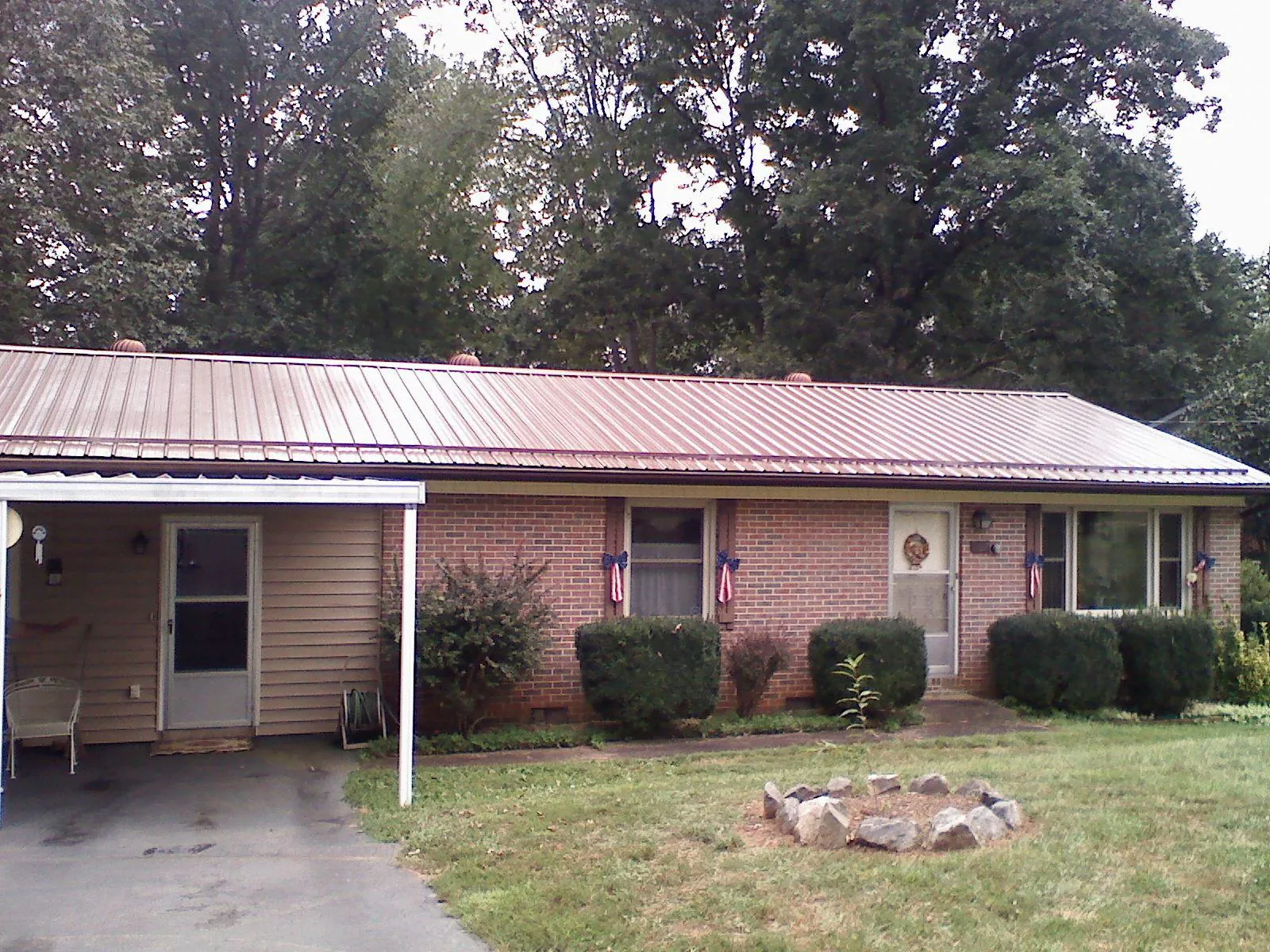 Bronze metal roof and carport on a brick ranch home — Roof Repair work by our crew in Stantonsburg